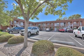 Albuquerque apartment for rent - A parking lot with cars and a building in the background.