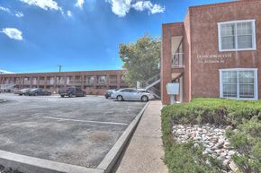 Albuquerque apartment for rent - A parking lot in front of a building with the words "LA HACIENDA ESTE" on it.