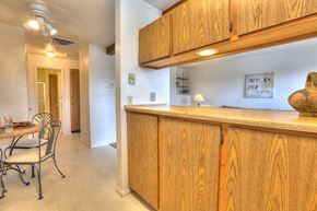 Albuquerque apartment for rent - A kitchen with wooden cabinets and a dining table with chairs.