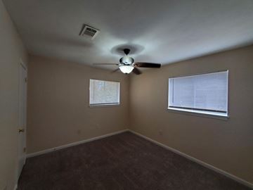 New Llano house for rent - a bedroom with a ceiling fan and a window