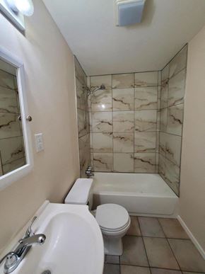 New Llano house for rent - a bathroom with a toilet and a tub and a sink