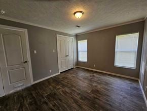 Shawnee house for rent - A room with wooden floors and three doors.