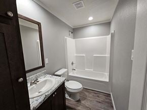 Shawnee house for rent - A bathroom with a toilet, sink, and bathtub.