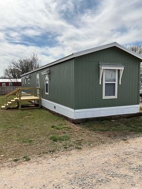 Shawnee house for rent - A green house with a white window and a wooden staircase.