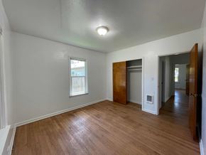 Kelso house for rent - the living room and dining room of an empty house with wood floors and a window