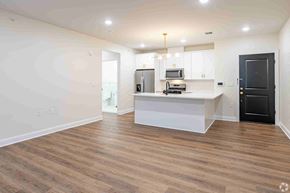 Plainfield apartment for rent - an empty living room with a kitchen and a black door