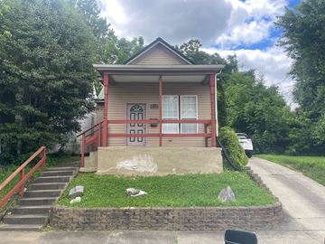 New Albany house for rent - the front of a small red house with a porch and stairs