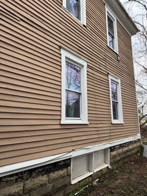 Syracuse apartment for rent - the side of a house with brown siding and white windows