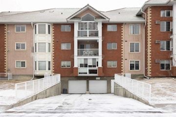Calgary house for rent - an apartment building with a garage door in the snow