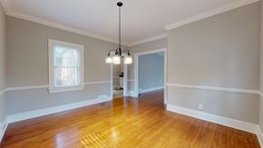 Greenville apartment for rent - A room with wooden floors and a chandelier hanging from the ceiling.