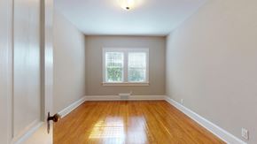 Greenville apartment for rent - A room with a wooden floor and a window with blinds.