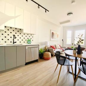 Vancouver apartment for rent - A modern kitchen with white cabinets and a black and white backsplash.