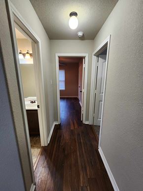 Killeen house for rent - a hallway with wood floors and a hall way to a bedroom and a bathroom