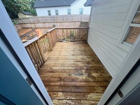 Atlanta apartment for rent - A wooden deck with a white house in the background.