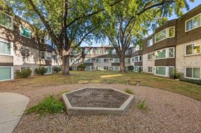 Minneapolis apartment for rent - A courtyard with a tree and a concrete structure in the middle.