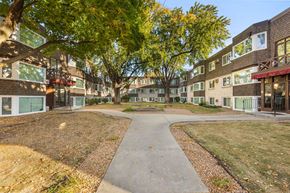 Minneapolis apartment for rent - A tree-lined walkway leads to a courtyard between two buildings.
