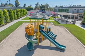 Santa Fe Springs apartment for rent - A playground with a yellow and green slide and a green and yellow structure.