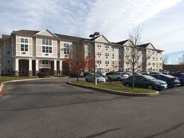 Stroudsburg apartment for rent - a parking lot with cars in front of an apartment building