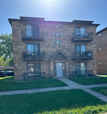 Calumet City apartment for rent - A building with a blue door and windows with black railings.