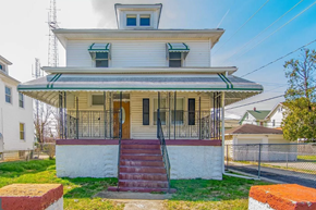 Baltimore house for rent - an old house with a porch and a staircase
