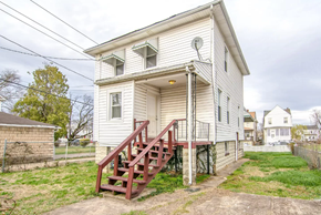 Baltimore house for rent - the front of a white house with red stairs