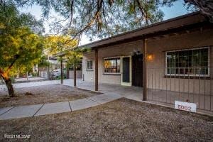Tucson house for rent - the front of a house with a sidewalk and a tree