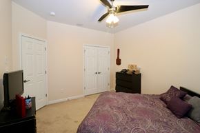 Newport News house for rent - a bedroom with a large bed and a ceiling fan