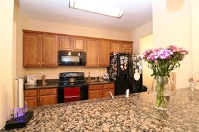 Newport News house for rent - a kitchen with a granite counter top with a vase of flowers