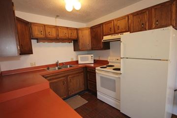 Whitefish apartment for rent - A white refrigerator is in a kitchen with wooden cabinets.