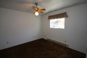 Whitefish apartment for rent - A room with a ceiling fan and a window with a curtain.