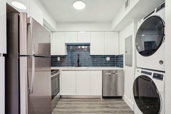 Sunrise apartment for rent - A modern kitchen with a stainless steel refrigerator and a washing machine.