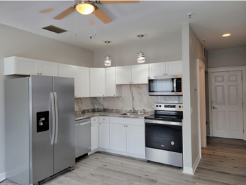 Fort Myers apartment for rent - A modern kitchen with a stainless steel refrigerator and white cabinets.