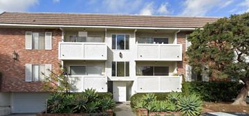 Santa Monica apartment for rent - an apartment building with a red brick facade and white balconies
