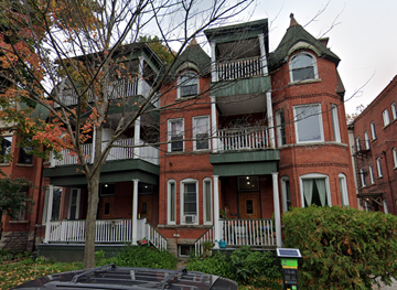 Ottawa apartment for rent - A large red brick house with a green trim.