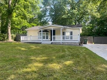 Atlanta house for rent - a small yellow house with a yard and a porch