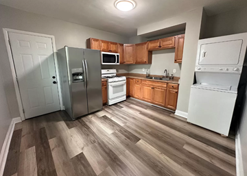 Baltimore house for rent - a kitchen with wooden floors and a stainless steel refrigerator