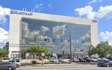 Houston apartment for rent - an office building with clouds reflected in the windows