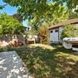 Victoria apartment for rent - a backyard with a small house and a garden