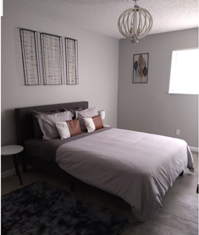 Wichita apartment for rent - a bedroom with a bed and a chandelier