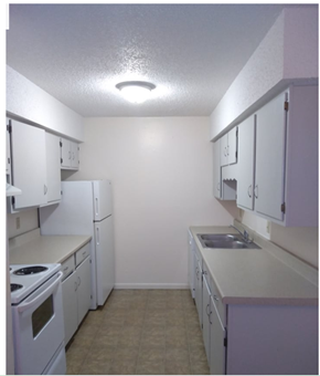 Wichita apartment for rent - an empty kitchen with white appliances and white cabinets