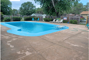 Wichita apartment for rent - a swimming pool in a backyard with chairs and a fence