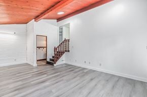 Edmonton house for rent - a renovated living room with white walls and a wooden staircase