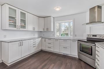 Edmonton house for rent - a kitchen with white cabinets and stainless steel appliances