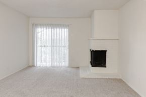 Tigard apartment for rent - A white room with a fireplace and a window with blinds.
