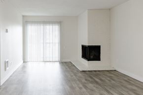 Tigard apartment for rent - A living room with a fireplace and a window with blinds.