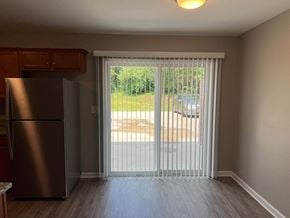 Shelbyville apartment for rent - a living room with a sliding glass door and a refrigerator