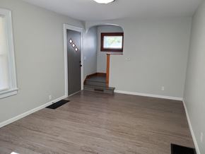 Lima house for rent - an empty living room with a hardwood floor and a door to a hall way