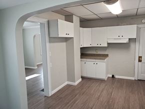 Lima house for rent - an empty kitchen with white cabinets and a wood floor