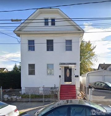 Carteret apartment for rent - A white house with a black door and red stairs.