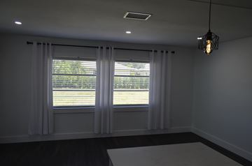 Cape Coral house for rent - a living room with two windows and white curtains